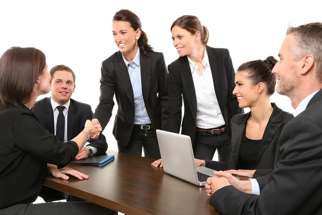 Two business professionals shaking hands during a meeting, representing customer retention