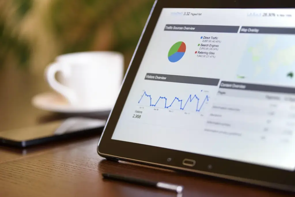 Person holding a tablet showing a customer retention dashboard with graphs