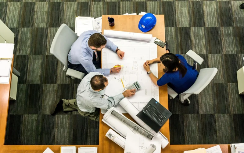 A diverse business team planning a customer retention strategy around a whiteboard