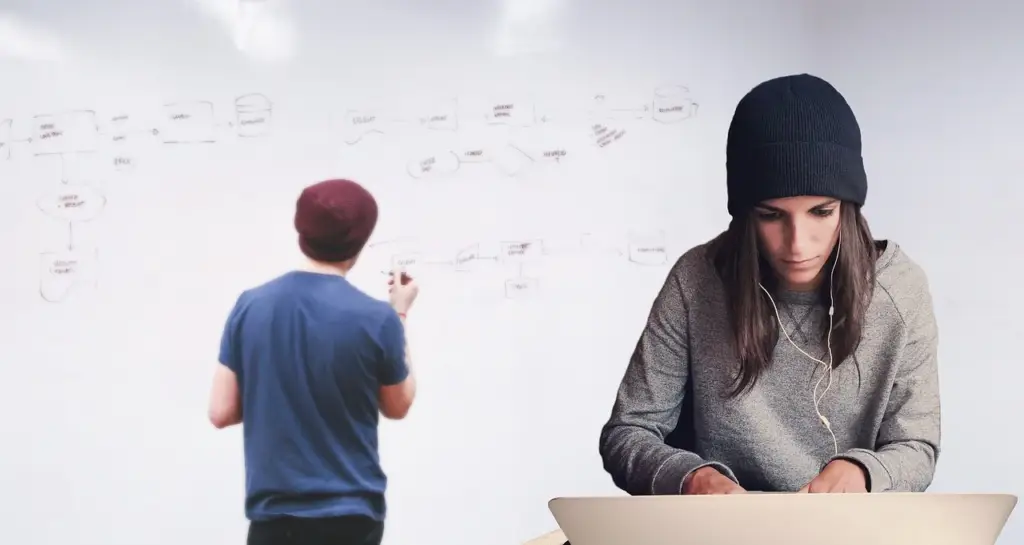 Team members analyzing churn data on a whiteboard, using insights from customer exit interviews